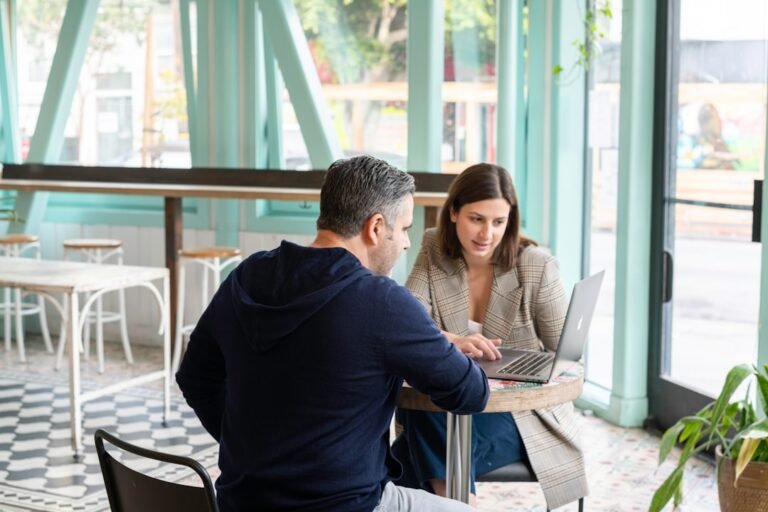 Small-business professionals discussing a customer referral over a laptop