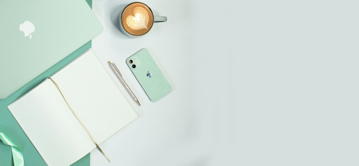 Marketing workspace with laptop and phone for planning Pinterest content